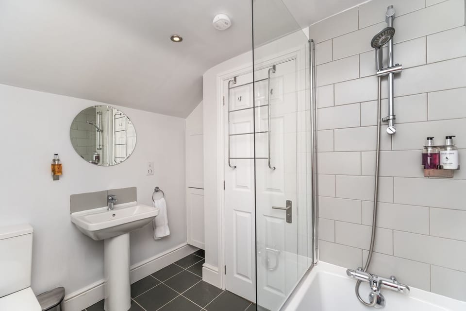 The bathroom comprises bath with overhead shower, hand sink and WC