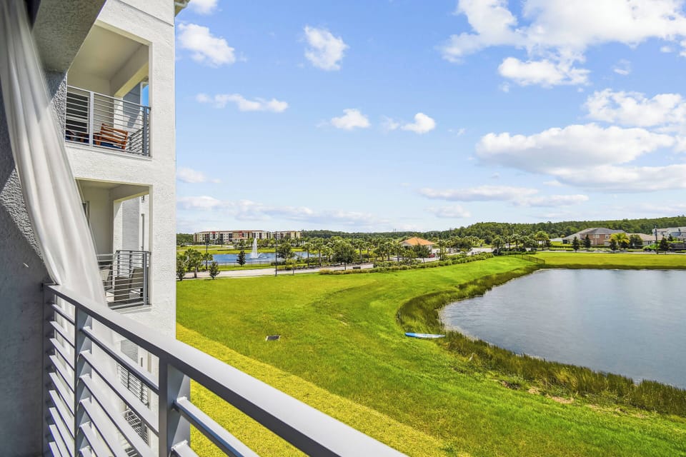 Enjoy the natural light on this spacious balcony, where sleek railings showcase beautiful views of lush greenery and a serene pond. Relax in the gentle breeze, ideal for savoring morning coffee or unwinding in the evening.
