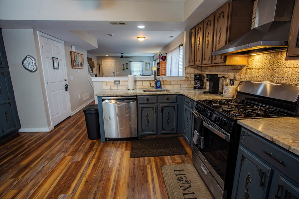 Spacious open kitchen with gas range, stainless appliances, and warm finishes