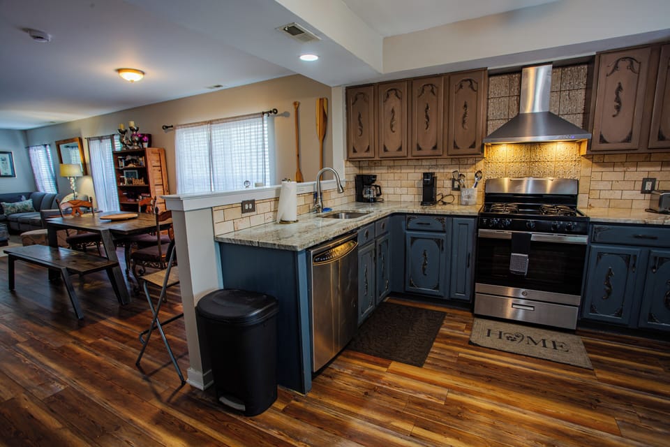Open-concept kitchen with granite counters and stainless steel appliances