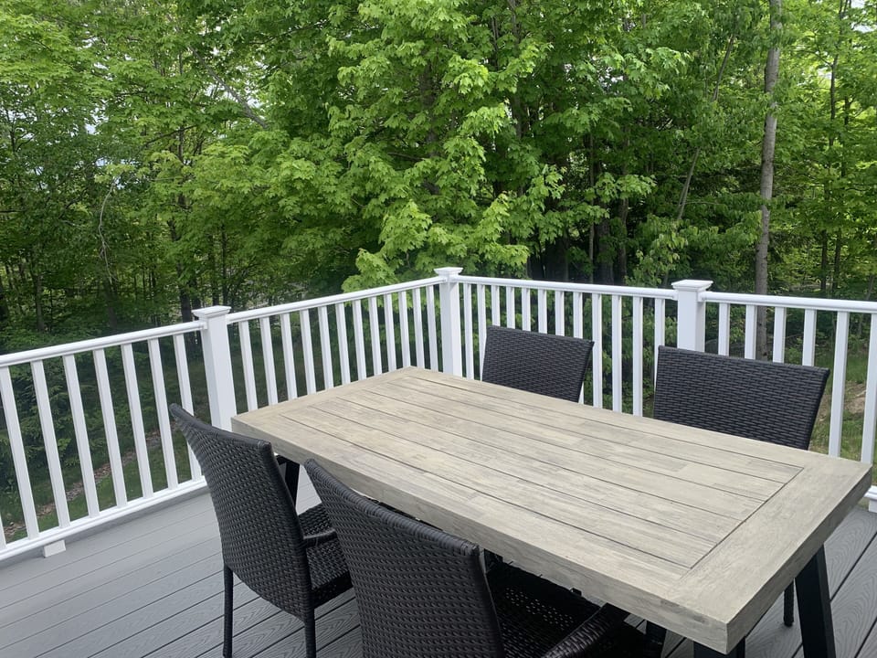 Back deck with table, chairs, and a bench. Wonderful for morning coffee/meals