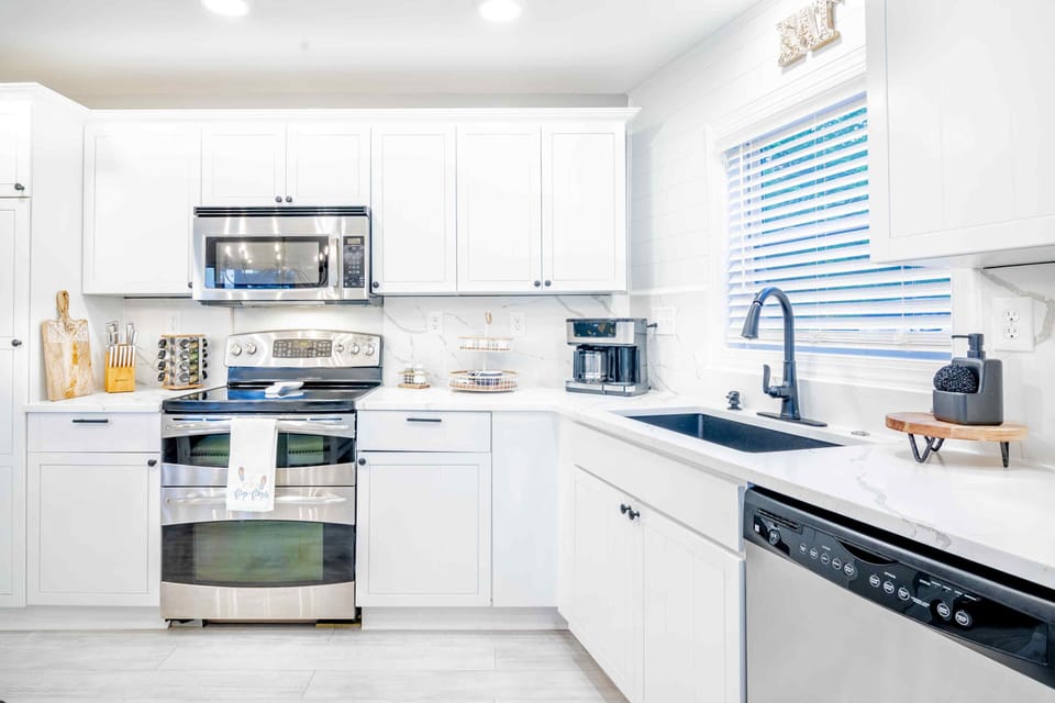 Fully equipped kitchen with stainless steel appliances and quartz countertops.