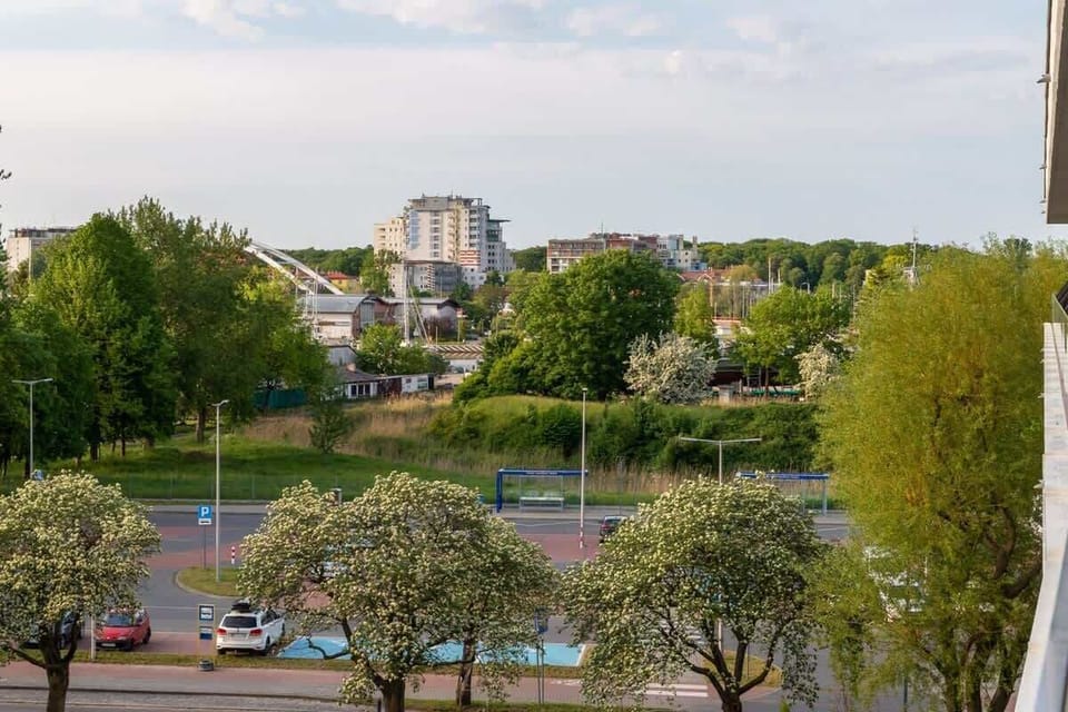 Scenic view of the city with green spaces and modern architecture in the distance.
