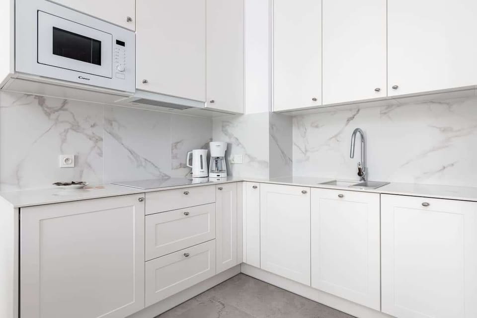 Modern kitchen featuring white cabinetry, built-in appliances, and clean lines.
