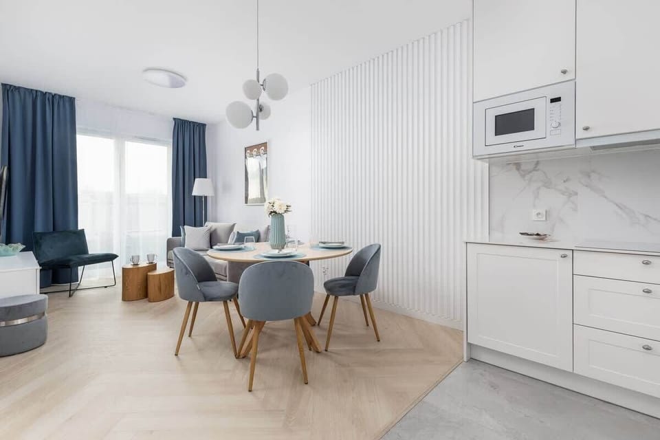 Dining area with a modern round table, upholstered chairs, and bright decor.

