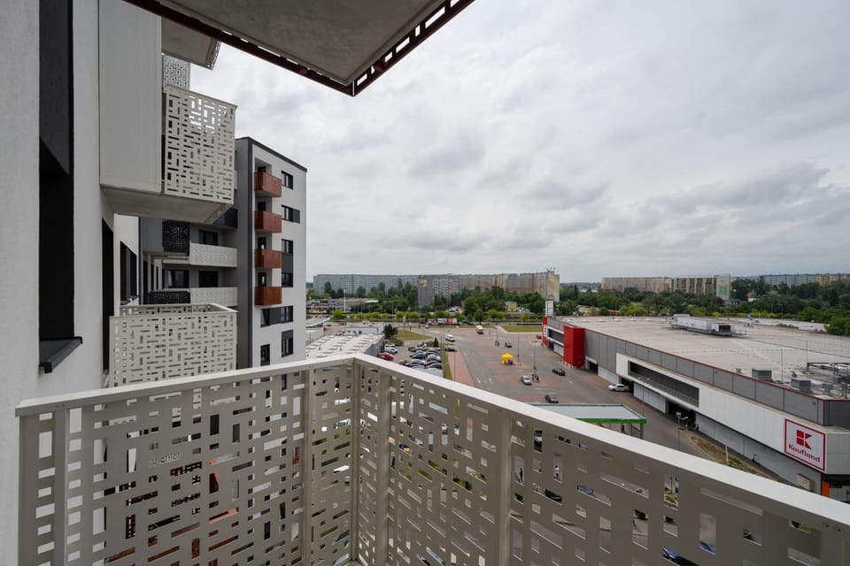 Balcony view with unique decorative privacy panels and a glimpse of the neighborhood.
