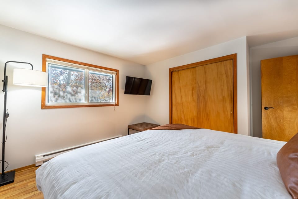 Drift off in this peaceful bedroom with natural light, modern amenities, and warm wood touches creating your perfect retreat.