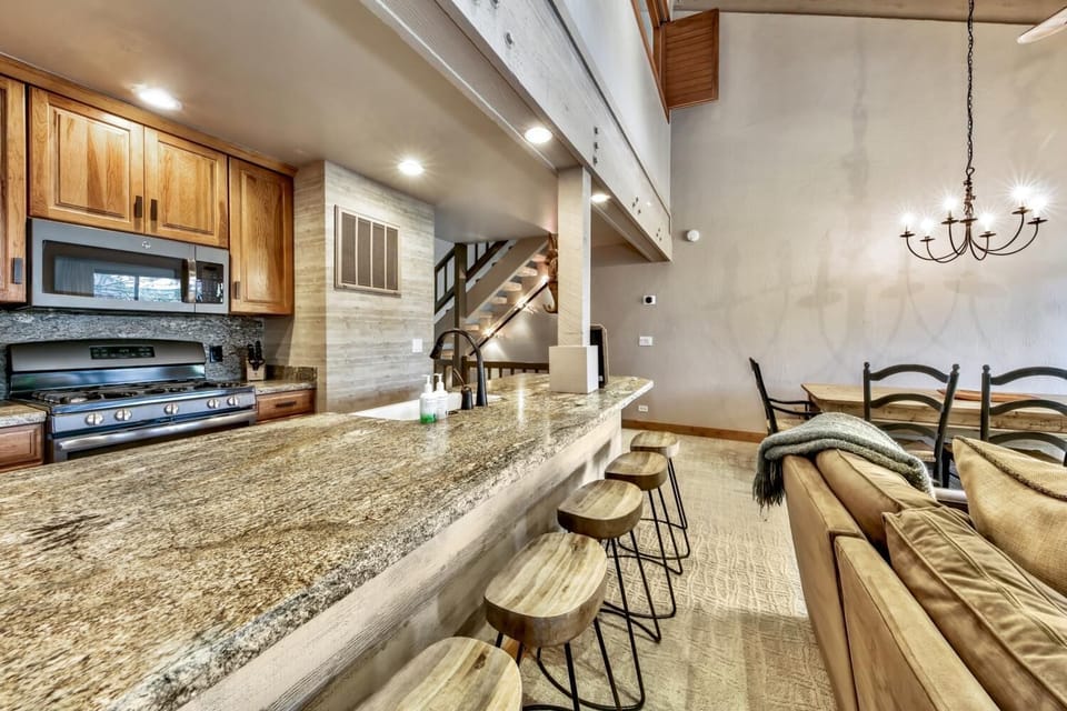 Gather around your spacious granite island where rustic wood meets modern comfort, perfect for morning coffee or evening conversations in this inviting open-concept space.