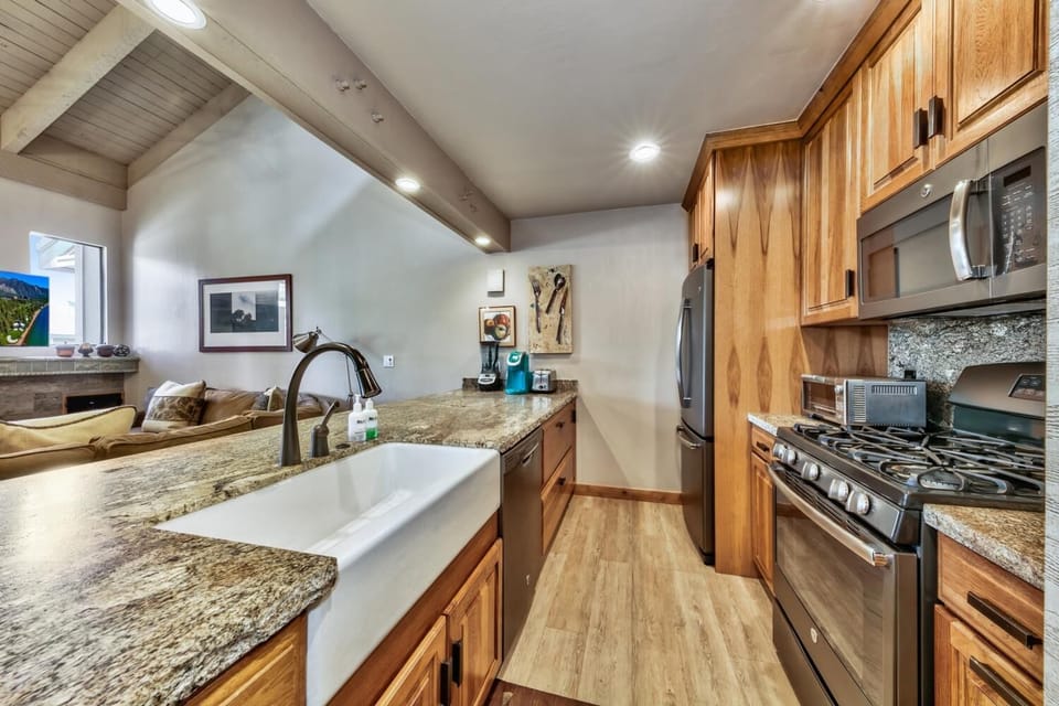 Your gourmet kitchen features granite counters, stainless appliances, and warm wood cabinetry perfect for preparing memorable meals together.