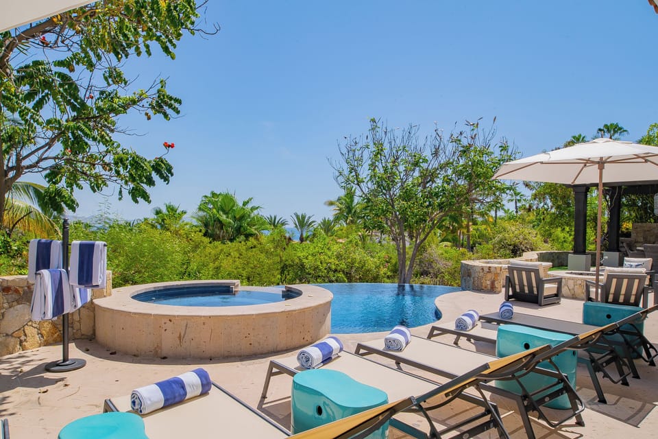 Unwind poolside in your private oasis, where turquoise loungers, a sparkling infinity pool, and a hot tub meet lush tropical gardens and ocean views beyond.