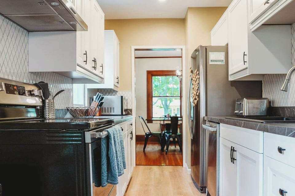 FULLY stocked kitchen! Full set of pots & pans, sheets pans, baking bans, serving dishes and bowls, mixing bowls, plates, bowls, glasses, silverware, KIDS plates//cups//utensils, food storage, toaster, microwave, oven, dishwasher and fridge.