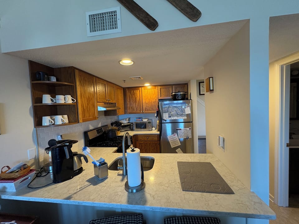 The fully equipped kitchen also has a counter eating area with three stools.
