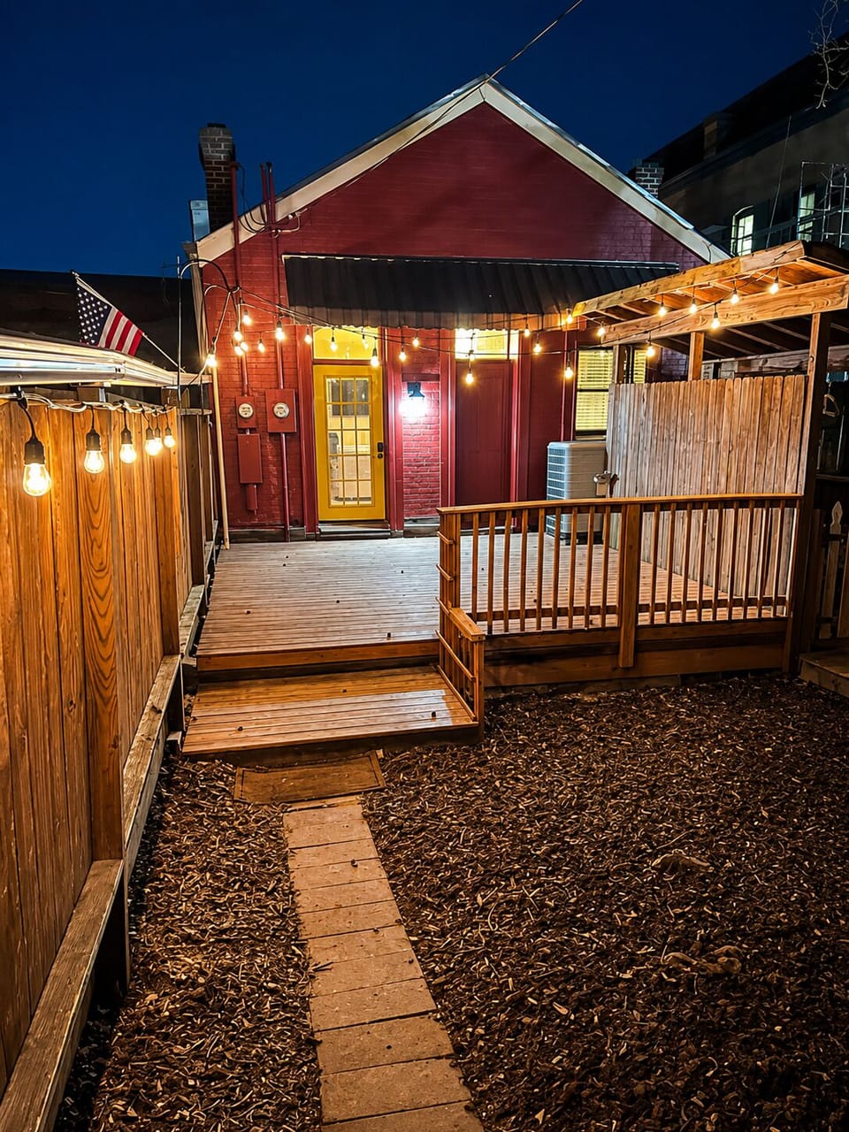 String lights illuminate the private patio walkway and steps to the unit's entrance.