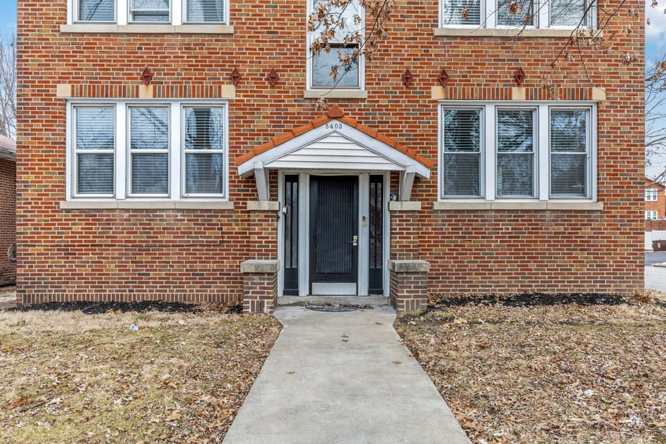Street-facing shared entrance framed by the brick facade, with the 5403 address visible above.