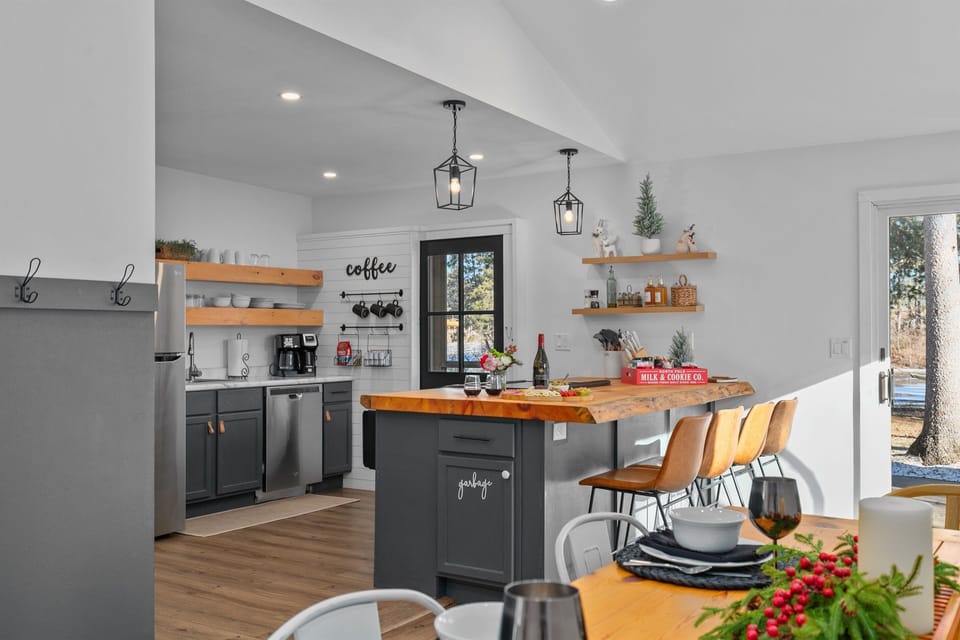 The natural wood island in the kitchen creates the perfect setting for guests to gather, share stories, and enjoy each other’s company while preparing meals