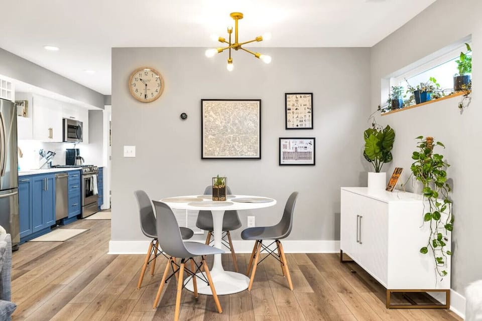 Enjoy the seamless blend of style and functionality in our dining space, where modern design meets homey comfort. Gather around the chic white table for a meal or a game, surrounded by the warmth of contemporary accents and a vibrant kitchen ready to insp
