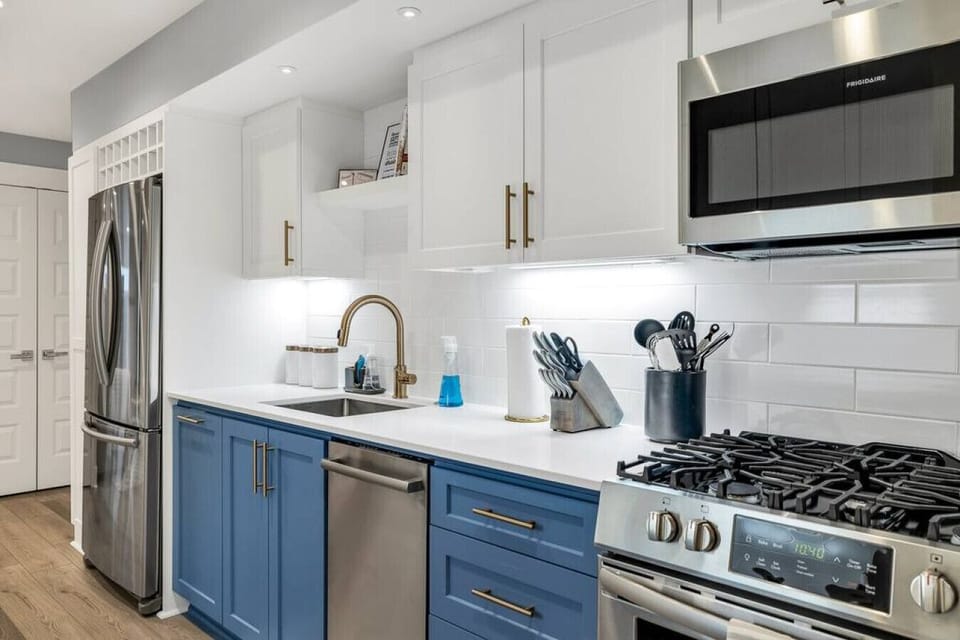 "Culinary elegance awaits in our newly renovated kitchen, featuring striking blue cabinetry and sleek white countertops. Modern and inviting, it's the perfect space for creating your favorite dishes."