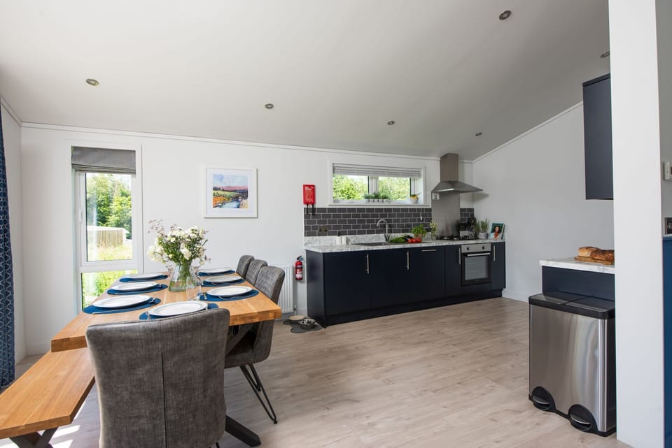 The dining table with seating for all guests and kitchen - Buttercup Lodge