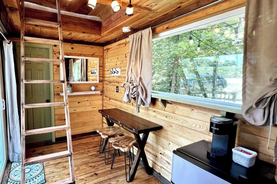 The ladder leads to the second story where there is a bedroom and lounge area. Can't wait for you to see, but before we head upstairs let me tell you more. You have a fridge that has plenty of space for your tiny home get-away and a K-mini-Keurig.