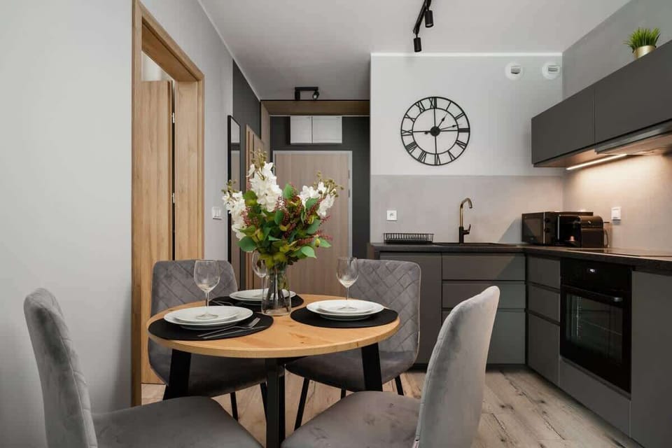Dining area with a round table and chairs in a modern, minimalist design.
