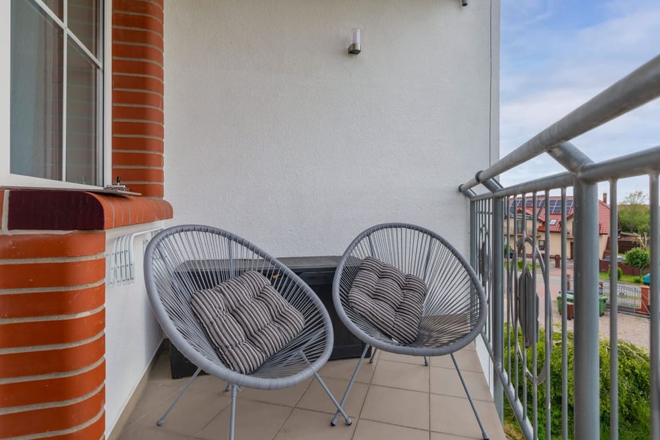 Furnished balcony with green surroundings. 