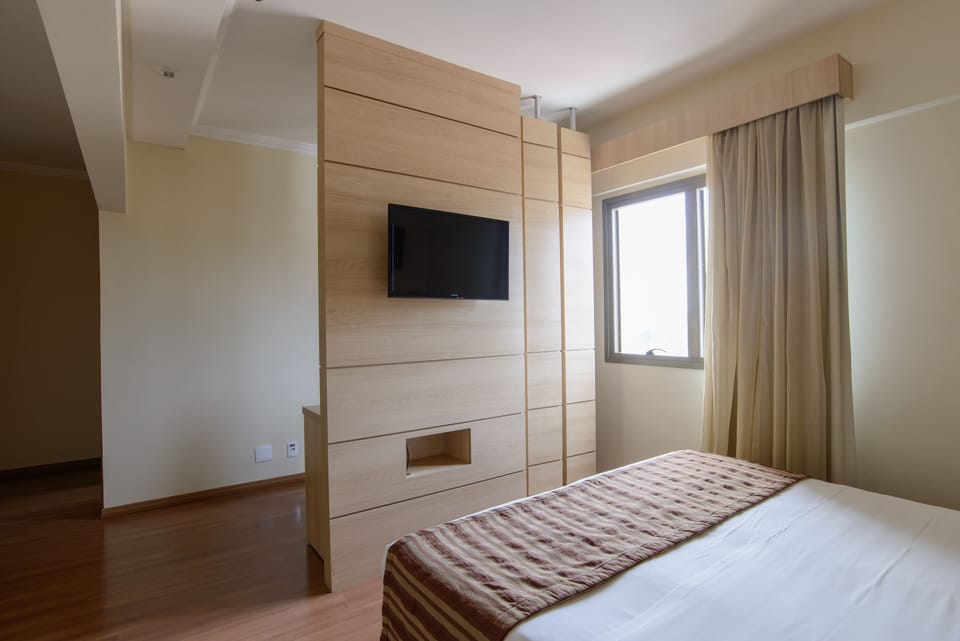 Deluxe Room | Minibar, in-room safe, laptop workspace, blackout drapes