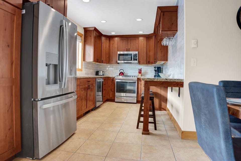 Fully equipped kitchen with French door refrigerator and stainless steel appliances