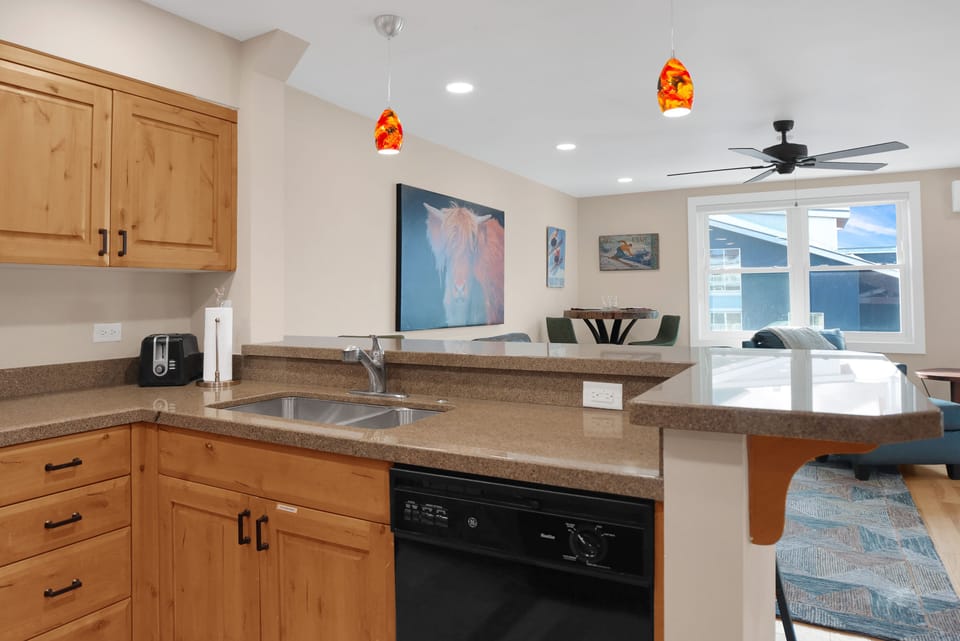 Dual level granite kitchen counters with wooden cabinetry
