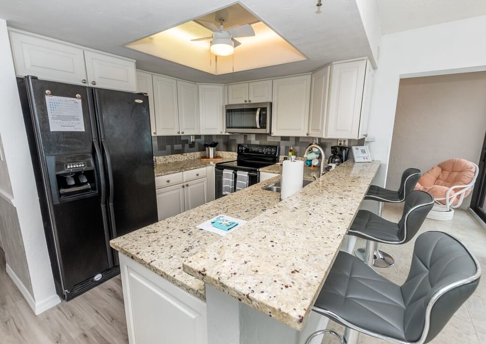 Kitchen with Toaster, Coffee Maker, Dishes, Cookware, Utensils.