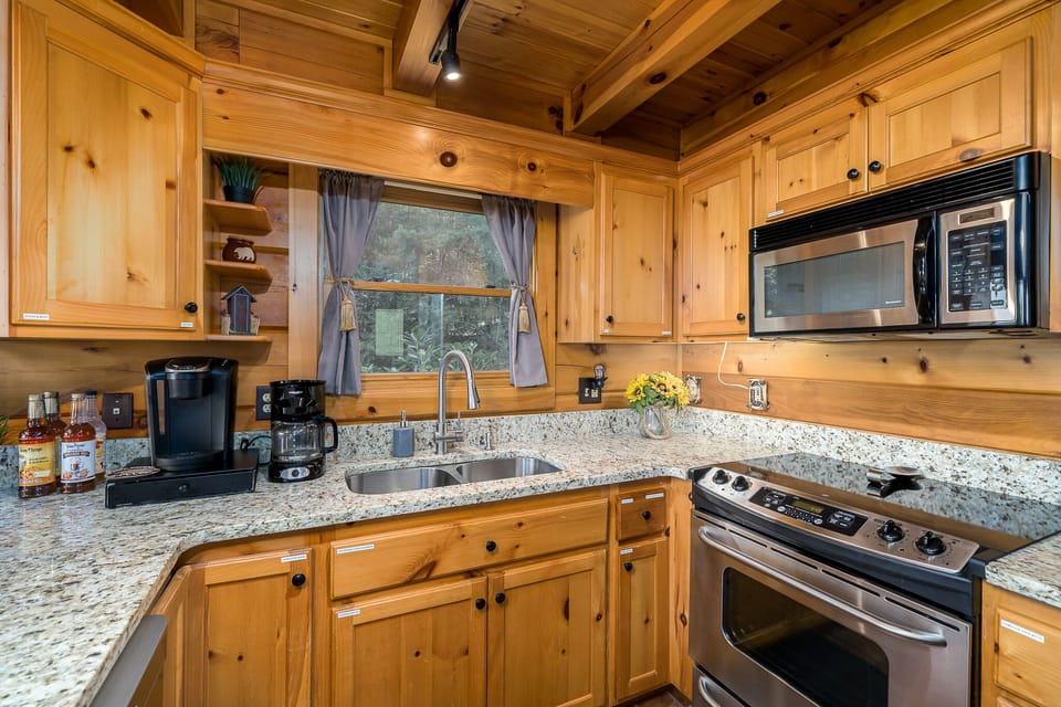 Stocked kitchen with coffee bar, stainless steel appliances, granite counters