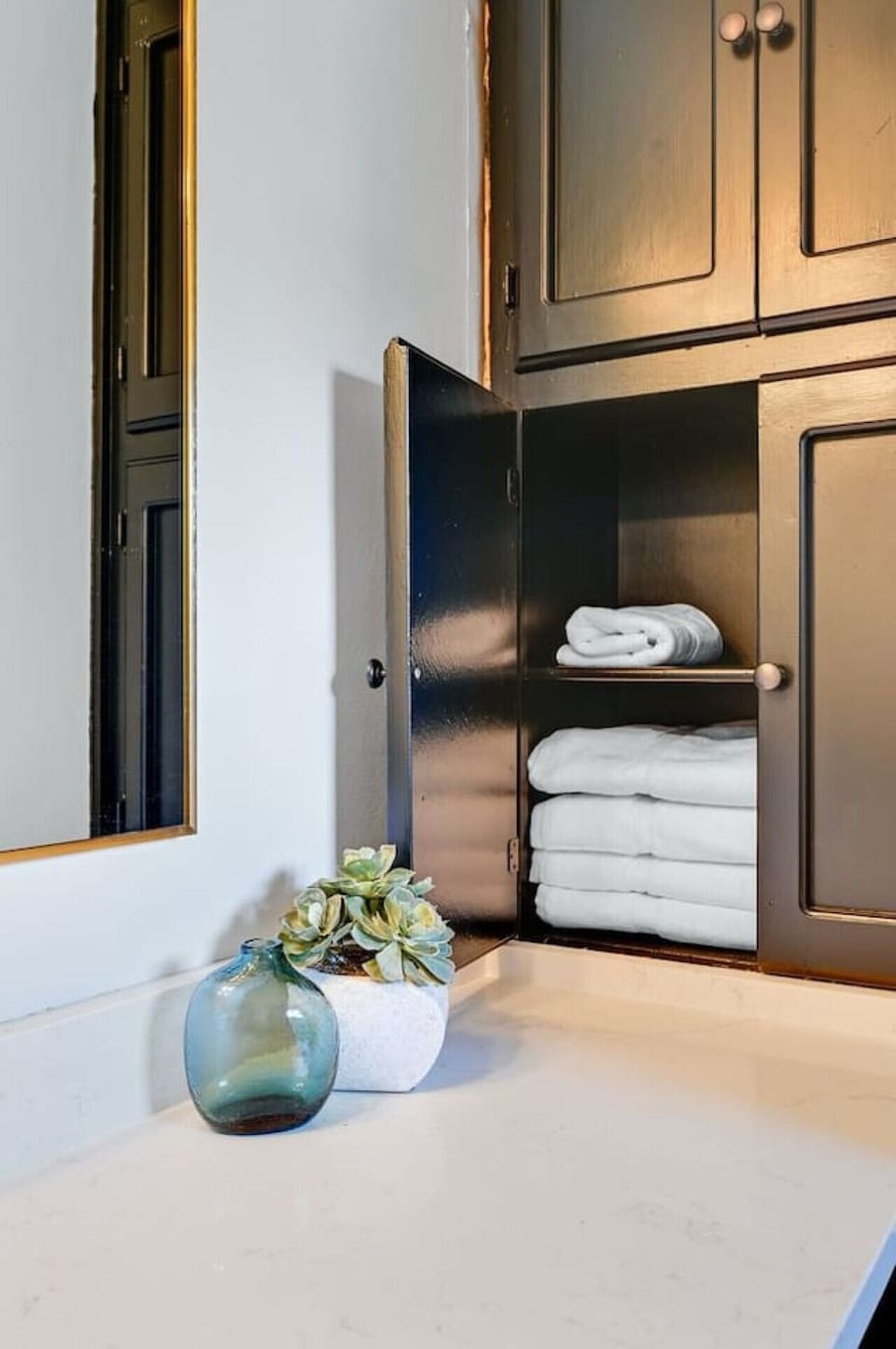 Bathroom storage stocked with fresh towels and simple decor—plenty of linens ready for your stay at Road Runner Lodge.