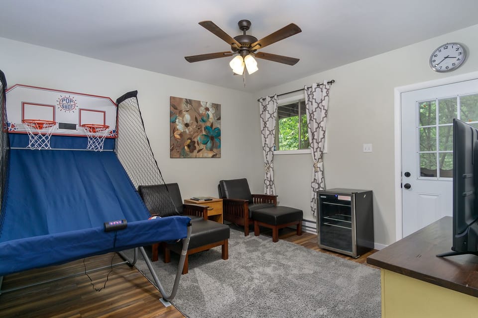 Lower-level game room with pop-a-shot basketball & cozy seating.