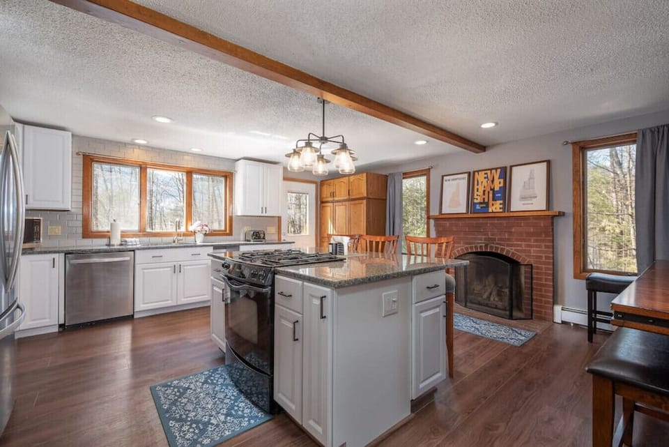 Beautifully appointed kitchen with high-end appliances, fireplace and dining table large enough to seat the whole family.