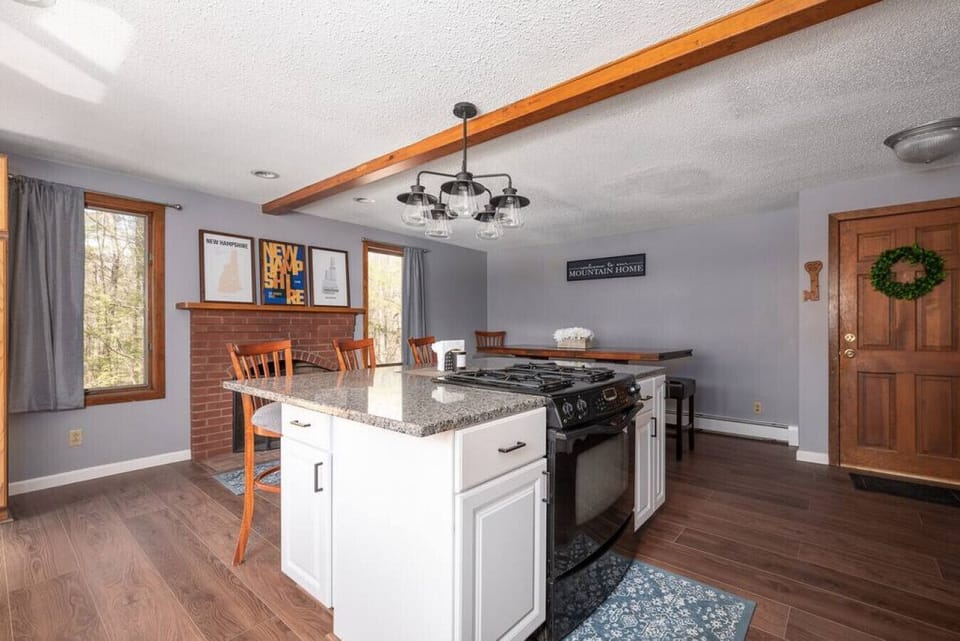 Kitchen island with Stove and cooktop with dining table in the background.