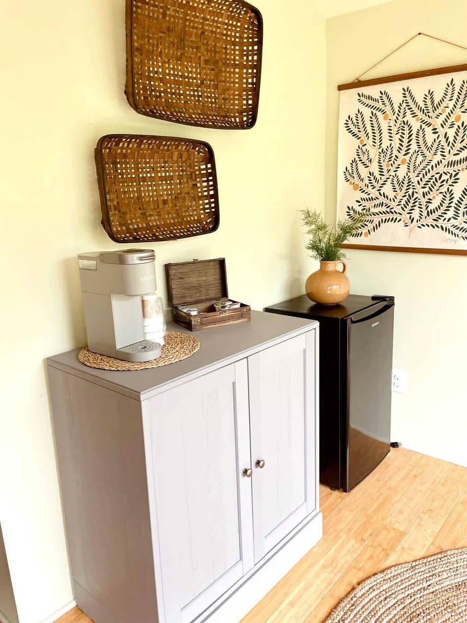Corner with the mini-fridge, Keurig coffee maker (coffee provided), and microwave is neatly hidden away in the gray cabinet. View of the king-size bed, looking at the bathroom door, and looking into the second room.
