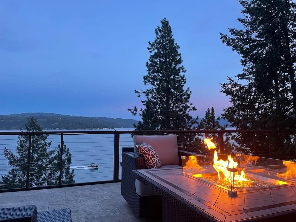 Evening lakeside terrace with fireplace creates perfect ambiance for your mountain getaway relaxation.