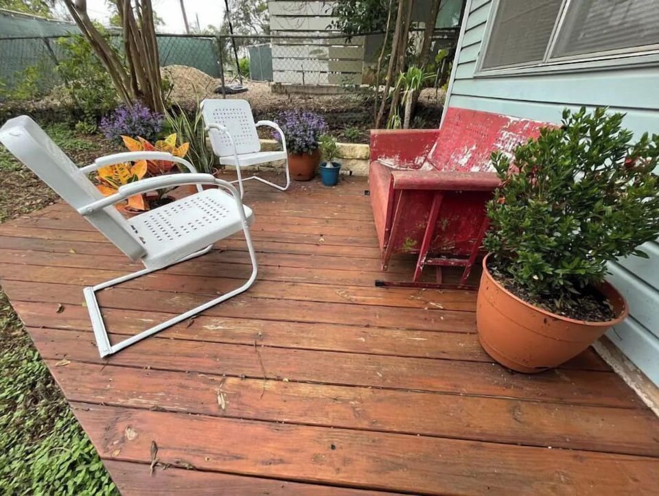 Patio in front with vintage glider and chairs. 