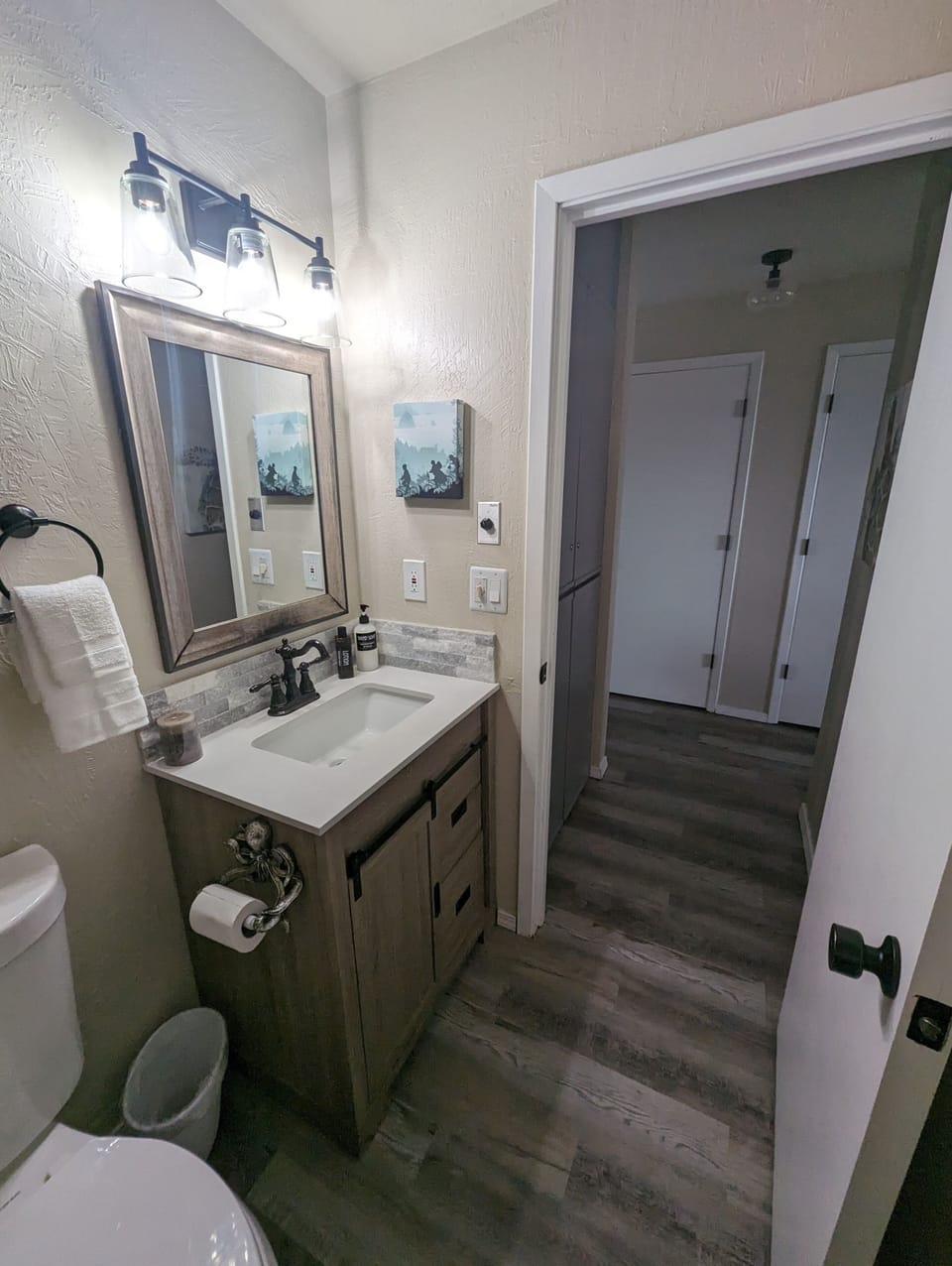 Hallway bathroom has water saving toilet, walk-in shower with bench seat.