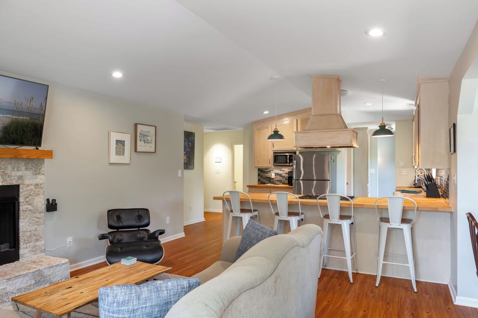 Open-concept kitchen and living area with SmartTV and a cozy indoor fireplace