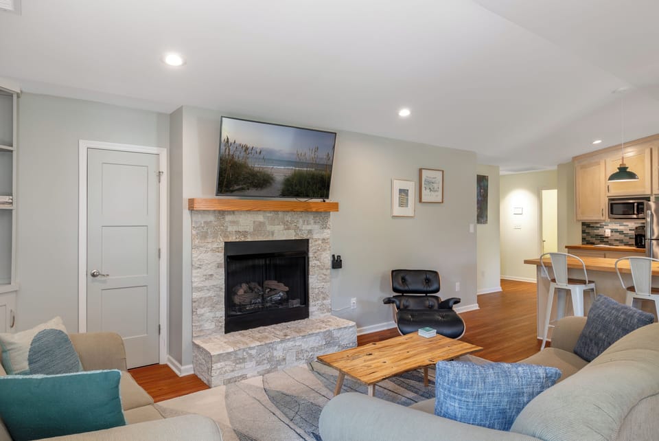 Open-concept kitchen and living area with SmartTV and a cozy indoor fireplace