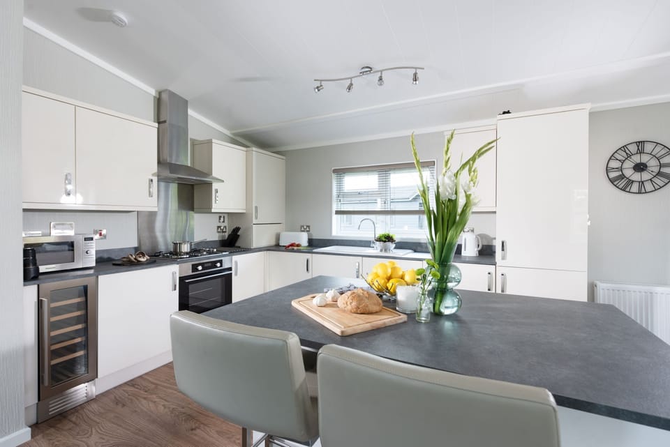 The kitchen and breakfast bar, wine fridge, stovetop and oven - Daisy Lodge