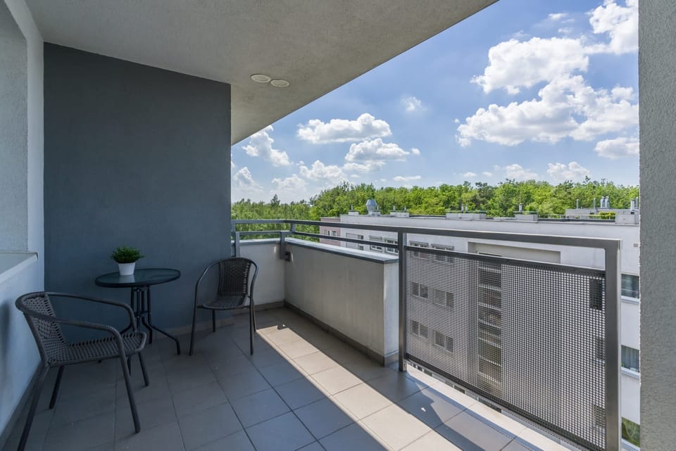 Furnished balcony with green surroundings. 