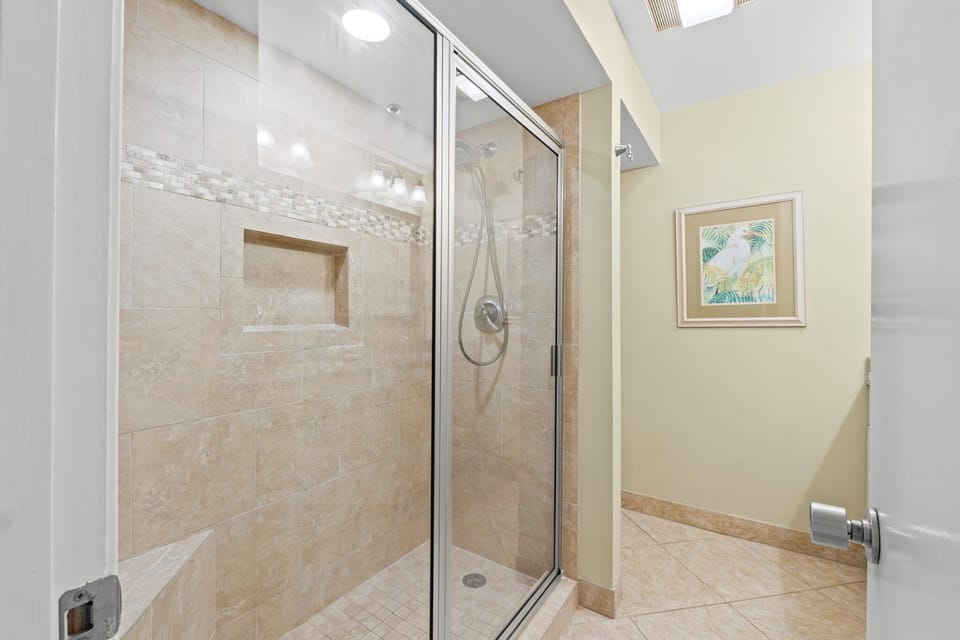 The master bath shines with granite counters, dual sinks, and ample cabinet storage. A sleek tiled walk-in shower awaits, along with fresh bath linens and complimentary toiletries including shampoo, conditioner, body wash, and lotion.