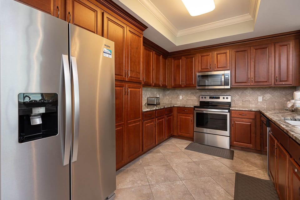 Whip up your favorite meals in this elegant kitchen, featuring stainless appliances and rich cabinetry