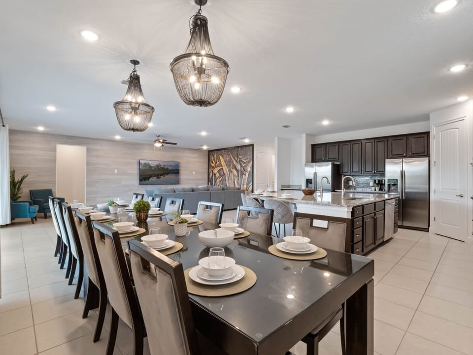 - Gather with family in this open concept dining and living area  
- Large table and modern kitchen perfect for group meals  
- Spacious Orlando vacation rental with family friendly design