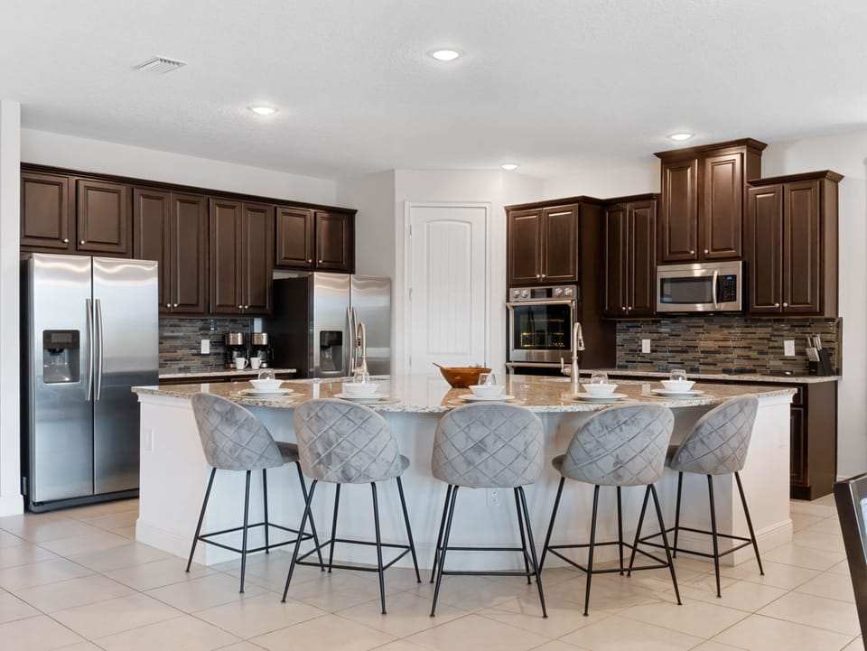 - Cook with ease in the modern kitchen featuring stainless steel appliances  
- Granite counters and spacious island seating for family meals  
- Orlando vacation rental with full kitchen for group stays