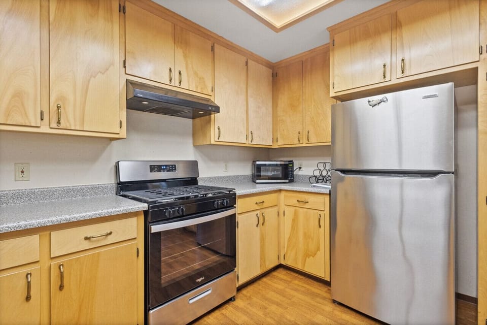 Kitchen is equipped with a gas stove, large fridge, microwave, cooking basics, coffee station