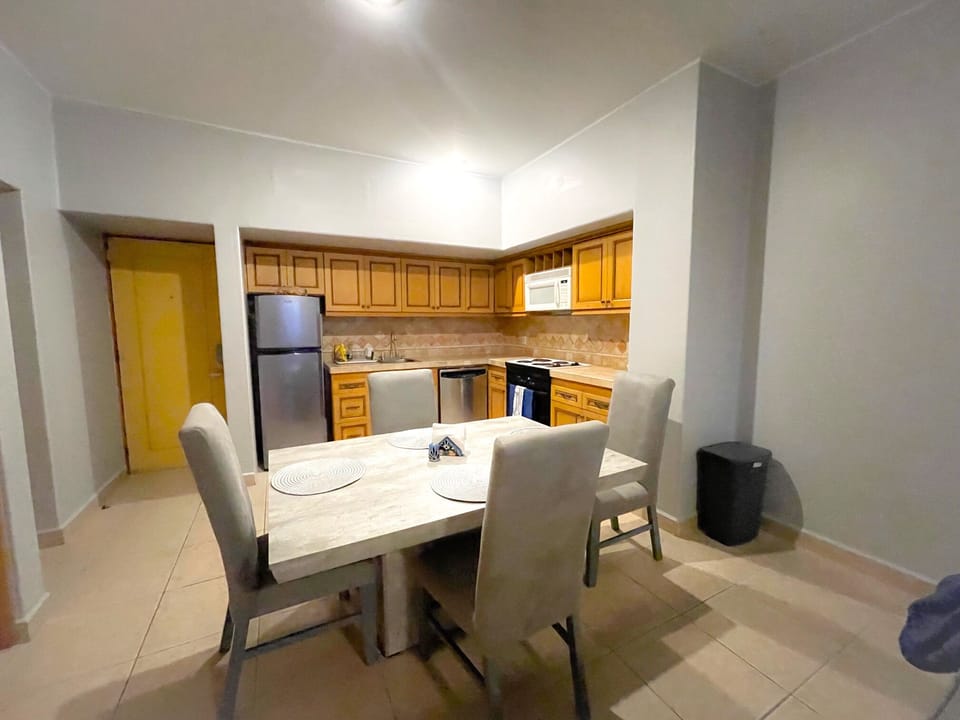 Dining set next to full kitchen with large appliances.