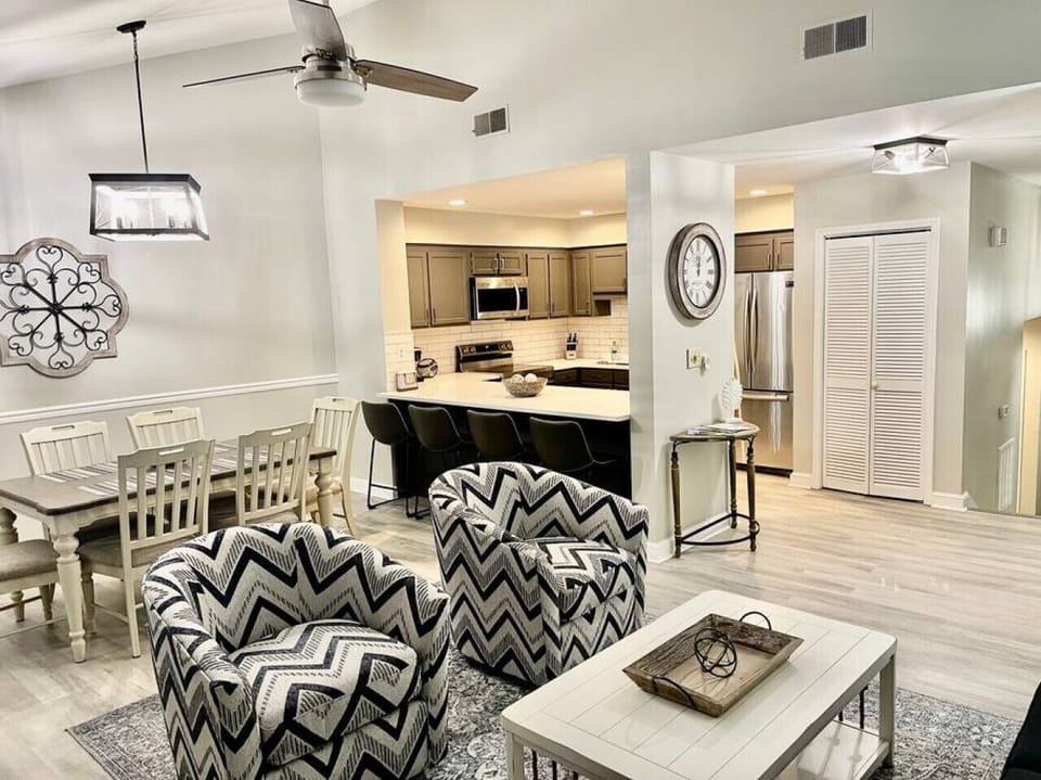 View of the open floor plan kitchen, dining and family room areas. Kitchen countertop stools seat 4 and dining table seats 6.