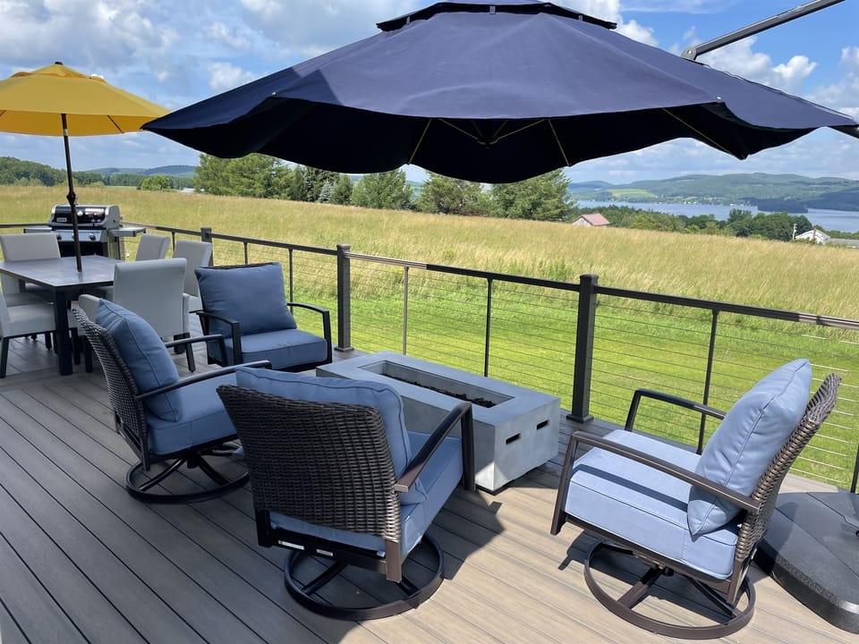 Lounge furniture, firepit, outdoor dining area overlooking lake